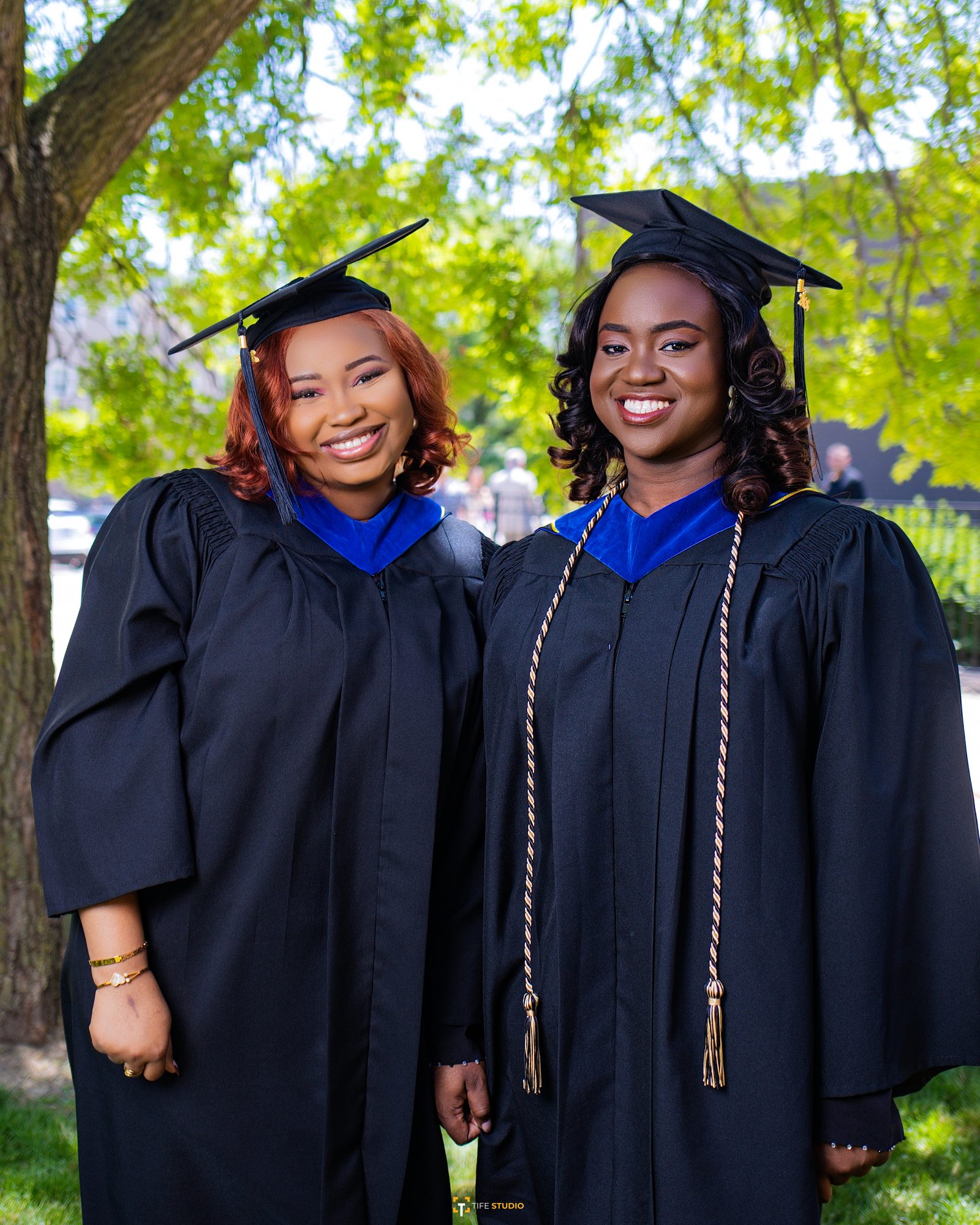 Two graduates together outdoors